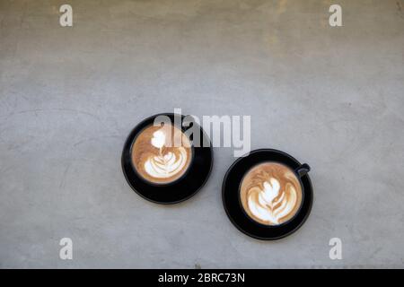 Zwei Tassen heißen Cappuccino auf weißem Holztisch Hintergrund. Platz für Text. Stockfoto
