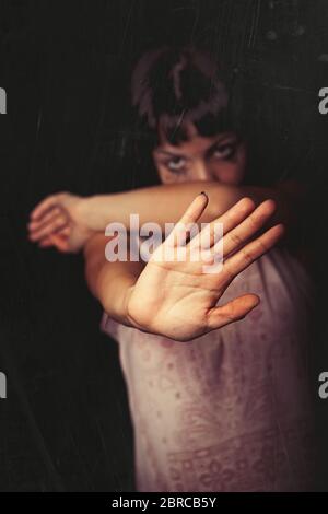 Ablehnung, Gewalt gegen Frauen. Ein junges Mädchen mit der Hand weg und lehnt Gewalt von jemandem. Tränen und Weinen. Schwarzer Hintergrund. Konzentrieren Sie sich auf das ha Stockfoto