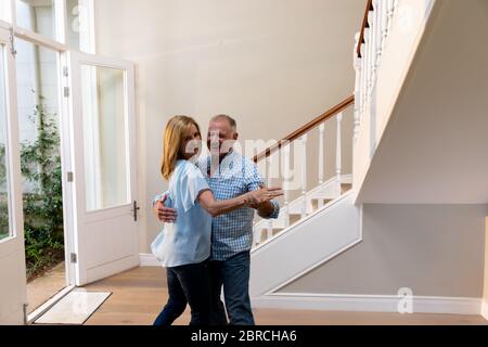 Kaukasisches Paar, das Spaß am Tanzen und Lächeln auf dem Flur hat Stockfoto