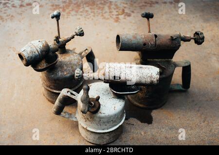 Alte rostige Gasbrenner steht auf einem rostigen Eisenblech. Metallschrott. Nahaufnahme. Stockfoto