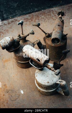 Alte rostige Gasbrenner steht auf einem rostigen Eisenblech. Metallschrott. Nahaufnahme. Stockfoto