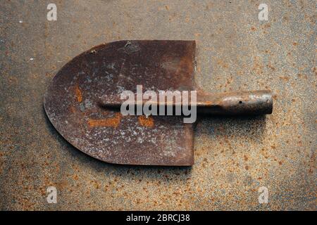 Alte rostige Bajonettspaten auf einem rostigen Eisenblech. Metallschrott. Nahaufnahme. Stockfoto