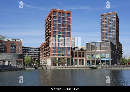 Gebäude am nördlichen Rand von Canada Water, London. Ein neu entwickeltes Gebiet auf dem Gelände der alten Surrey Docks. Zeigt den Tennisplatz auf dem Dach (rechts). Stockfoto