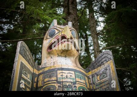 Totem Bight State Historical Park, Ketchikan, Alaska, USA, zeigt Replik und restaurierte Totempfähle der Ureinwohner Amerikas einschließlich Adlergrabstein Stockfoto