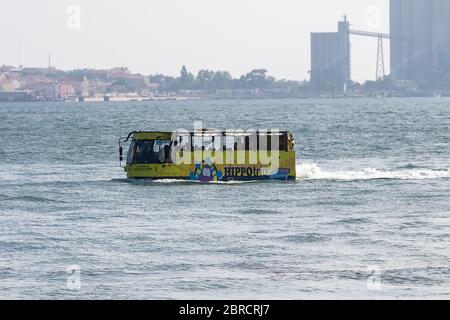 Lissabon, Portugal - 15. Juli 2019: Komfortable Fahrt mit dem Gelben Bus an Land und auf dem Fluss Tejo. Amphibienbus schwimmt auf der Bucht von Lissabon, Portugal Stockfoto