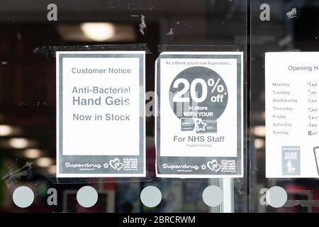 Superdrug-Shop während der Coronavirus-Pandemie mit Schildern Werbung antibakterielle Handgele jetzt auf Lager und 20% Rabatt für nhs-Mitarbeiter - Glasgow Stockfoto