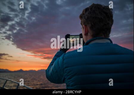 Kleine Schiffsrundfahrten in Stephens Passage, Südost-Alaska, USA bieten Touristen wunderschöne landschaftliche Aussichten wie diesen feurigen Sonnenuntergang über der Inside Passage. Stockfoto