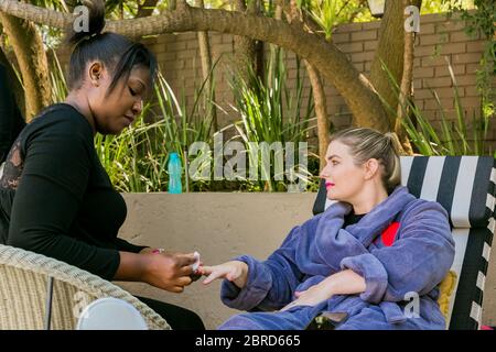 Johannesburg, Südafrika - 10. Mai 2018: Diverse Frauen in Bademänteln erhalten eine Maniküre im Spa Resort Stockfoto