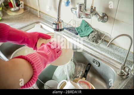 Männer mittleren Alters waschen nach dem Essen Geschirr im Waschbecken. Stockfoto