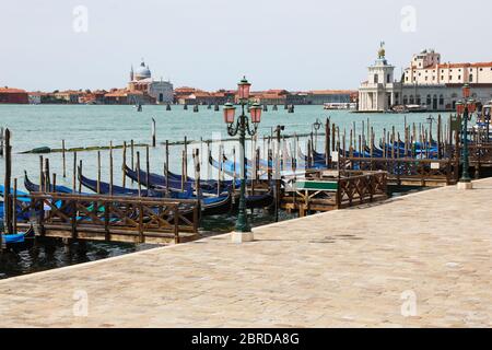 Viele Gondeln, die in Venedig in Italien in der Nähe des Markusplatzes festgemacht wurden, haben wegen der Corona-Virus-Epidemie, die die Grenzen blockiert hat, ohne Touristen vertäut Stockfoto