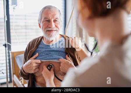 Eine Ärztin untersucht den Patienten im Bett im Krankenhaus. Stockfoto