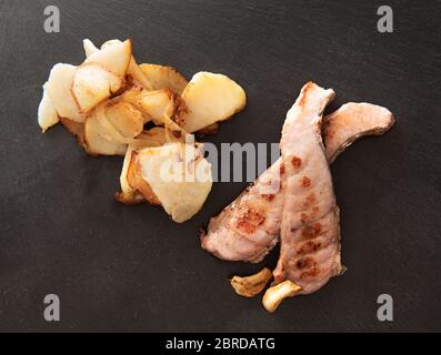 Fisch Thunfisch mit Bratkartoffeln auf einem dunklen Teller Stockfoto