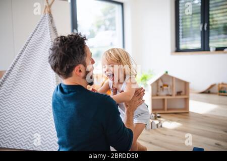 Junge Familie mit kleinen Kindern drinnen im Schlafzimmer Spaß haben. Stockfoto