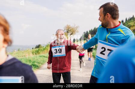 Große Gruppe von Menschen mit mehreren Generationen, die einen Wettlauf in der Natur betreiben. Stockfoto