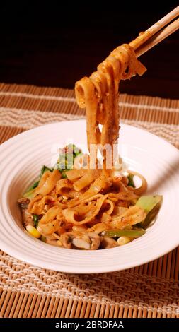 DAN DAN GLUTENFREIE NUDELN MIT MAIS, PAK CHOY, PILZE, CAPSICUM, ZWIEBELN, SPINAT Stockfoto