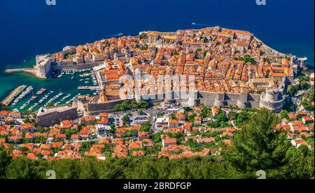 Ein Blick aus einem hohen Winkel auf die gesamte Altstadt von Dubrovnik, Kroatien, umgeben von Steinmauern und einem kleinen Bootshafen, der zur Adria hin offen ist. Stockfoto