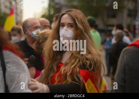 Mehrere hundert Menschen haben den zentralen Paseo de la Habana in Madrid abgeschnitten, um gegen die Regierung Pedro Sánchez vorzugehen. Viele der Demonstranten trugen Masken und einige sogar Handschuhe, aber angesichts der Menschenmenge war es unmöglich, die vom Gesundheitsministerium empfohlene soziale Distanz zu respektieren, um die Ausbreitung der Pandemie zu verhindern. Die Anhebung spanischer Flaggen und Kochtöpfe haben Schreie wie "Regierung resigniert!", "Freiheit!" gesungen. Oder "Sánchez a Prison", zusammen mit anderen isolierten "Wir sind Spanier, nicht Venezolaner." Sechs Lieferwagen des Nationalen Polizeikorps sind am Tatort eingefallen und haben sich dem Umkreisen von Th gewidmet Stockfoto