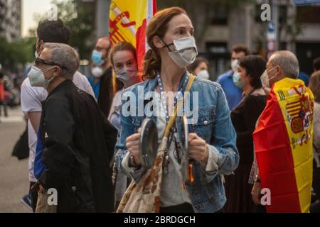 Mehrere hundert Menschen haben den zentralen Paseo de la Habana in Madrid abgeschnitten, um gegen die Regierung Pedro Sánchez vorzugehen. Viele der Demonstranten trugen Masken und einige sogar Handschuhe, aber angesichts der Menschenmenge war es unmöglich, die vom Gesundheitsministerium empfohlene soziale Distanz zu respektieren, um die Ausbreitung der Pandemie zu verhindern. Die Anhebung spanischer Flaggen und Kochtöpfe haben Schreie wie "Regierung resigniert!", "Freiheit!" gesungen. Oder "Sánchez a Prison", zusammen mit anderen isolierten "Wir sind Spanier, nicht Venezolaner." Sechs Lieferwagen des Nationalen Polizeikorps sind am Tatort eingefallen und haben sich dem Umkreisen von Th gewidmet Stockfoto