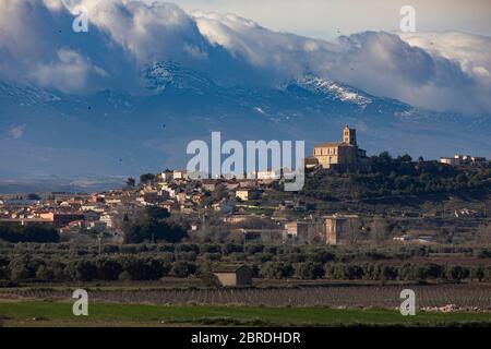 Morgenweite Sicht auf die Skyline von Magallón, einer der Städte in der Region Campo de Borja, mit Moncayo im Hintergrund, umgeben von Wolken und sn Stockfoto