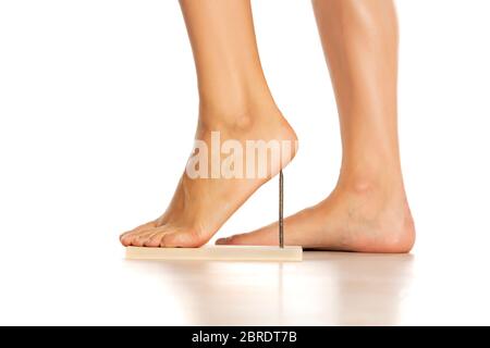 Ein Frauenfuß mit einem Nagel darunter. Konzept für High Heels Stockfoto