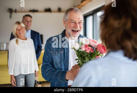 Gruppe von älteren Freunden beim Abendessen Party zu Hause, Gruß. Stockfoto