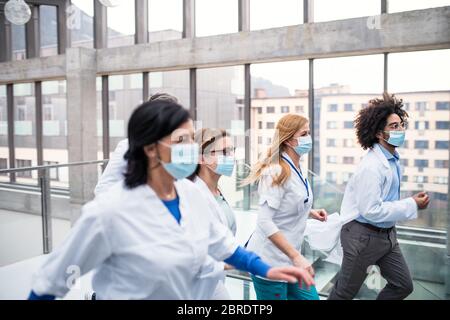 Gruppe von Ärzten mit Gesichtsmasken laufen, Corona-Virus-Konzept. Stockfoto