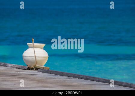 Holzsteg in Richtung einer kleinen Insel im Indischen Ozean, Malediven. Sonnigen blauen Himmel. Stockfoto