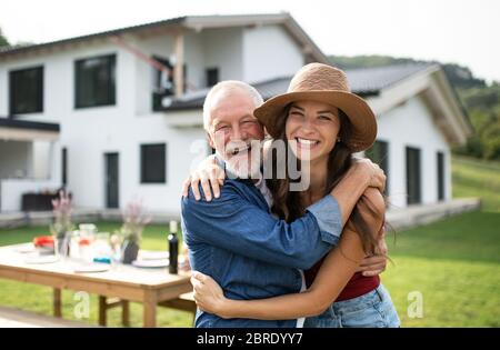 Senior Vater mit Tochter im Freien im Hinterhof, Blick auf die Kamera. Stockfoto