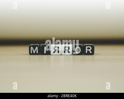 SPIEGELWORT in Würfel geschrieben auf Holzboden auf weißem Hintergrund, Buchstabenblöcke angeordnet in SPIEGELWORTE, für das Hinzufügen von Text oder andere Bilder oder Design Stockfoto