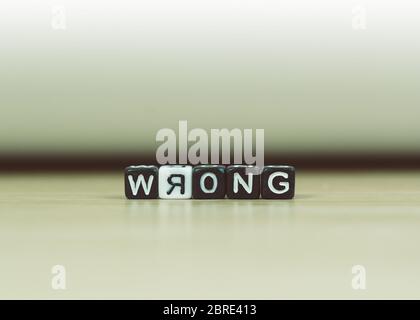 FALSCHES Wort geschrieben in Würfel auf Holzboden auf weißem Hintergrund, Buchstabenblöcke ordnet in FALSCHE Wörter, für das Hinzufügen von Text oder andere Bilder oder Design Stockfoto