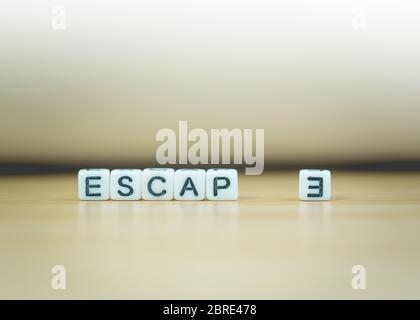 ESCAPE Word geschrieben in Würfel auf Holzboden auf weißem Hintergrund, Buchstaben Blöcke angeordnet in ESCAPE Worte, für das Hinzufügen von Text oder andere Bilder oder Design Stockfoto