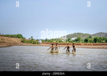 Phan Thiet, Provinz Binh Thuan, Vietnam - 16. Mai 2020: Jungs aus einem kleinen Dorf spielen Fußball im Schlamm, so glücklich und lustig in Phan Thiet, Vietnam Stockfoto