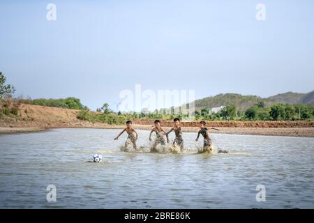 Phan Thiet, Provinz Binh Thuan, Vietnam - 16. Mai 2020: Jungs aus einem kleinen Dorf spielen Fußball im Schlamm, so glücklich und lustig in Phan Thiet, Vietnam Stockfoto