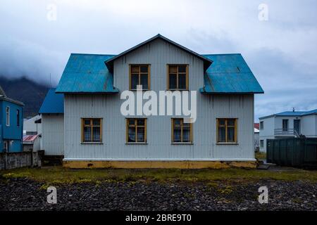 Landschaft in der Stadt Ólafsfjörður, im Norden islands. Das typische Haus hat eine weiße Fassade und ein blaues Dach. Stockfoto