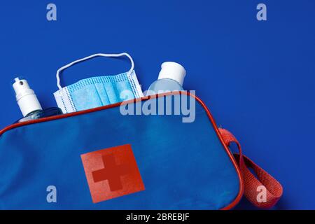 Erste-Hilfe-Set mit Maske und Desinfektionsmittel auf blauem Hintergrund Stockfoto