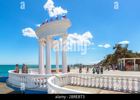 ALUSCHTA, KRIM - 15. MAI 2016: Die Menschen besuchen den städtischen Strand auf der Krim, Russland. Landschaftlich schöne Aussicht auf das Schwarze Meer in Krim. Weißer Kolonnade Witz Stockfoto