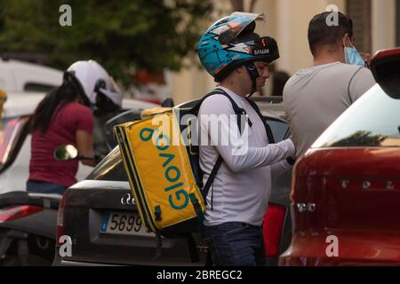 Madrid, Spanien - 19. Mai 2020: Lieferleute der Hauszustellung, Glovo, arbeiten auf den Straßen von Madrid und liefern Lebensmittel in der Rush Hour. Stockfoto