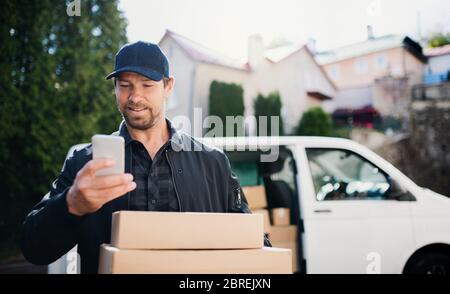 Delivery man Kurier Lieferung Paketkasten in der Stadt mit Smartphone. Stockfoto