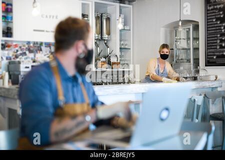 Besitzer von Cafés arbeiten mit Gesichtsmasken, nach der Sperrung der Quarantäne geöffnet. Stockfoto