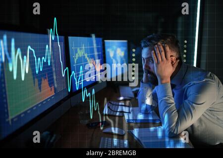 Frustrierter Geschäftsmann mit Computer am Schreibtisch, Finanzkrise und Corona-Virus-Konzept. Stockfoto