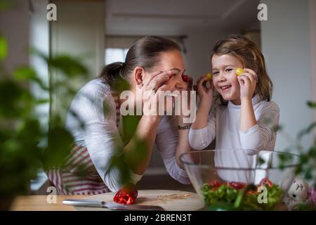 Kleines Mädchen mit älterer Großmutter in der Küche drinnen zu Hause, Spaß haben. Stockfoto