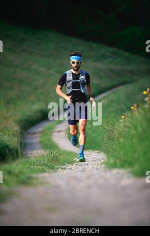 Mann mit Bartsportler, der während eines Trainings in den Bergen läuft Stockfoto