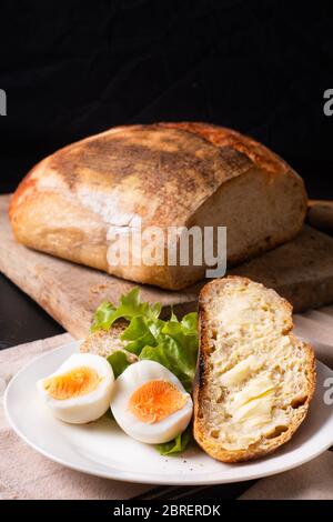 Gesundes Essen Food Konzept hausgemachte Bio-Sauerteig Brot und gekochtes Ei in weißen Teller mit Kopierer Raum Stockfoto