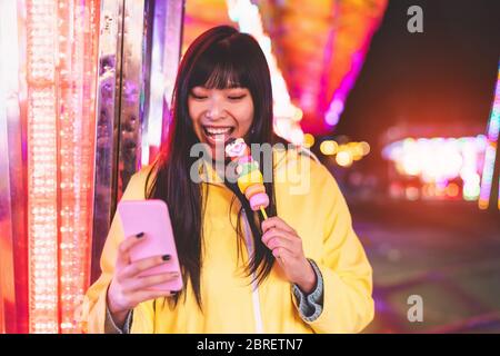 Asiatische Mädchen nehmen mit Handy im Vergnügungspark - Happy Woman mit Spaß mit neuen Trends Smartphone-Apps Stockfoto