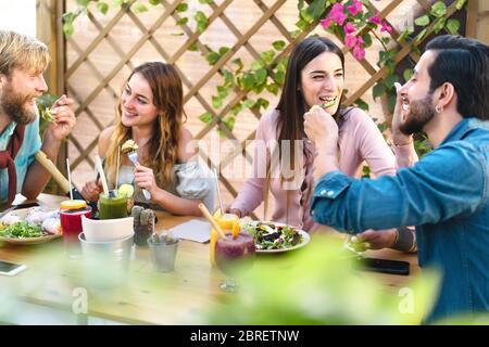 Glückliche Freunde essen mit gesundem Essen in Bar Kaffee Brunch - Junge Menschen Spaß Essen und Trinken Smoothies frisches Obst Stockfoto