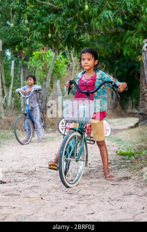 Junge kambodschanische Mädchen auf dem Fahrrad halten auf einer kleinen Strecke. Provinz Siem Reap, Kambodscha, Südostasien Stockfoto