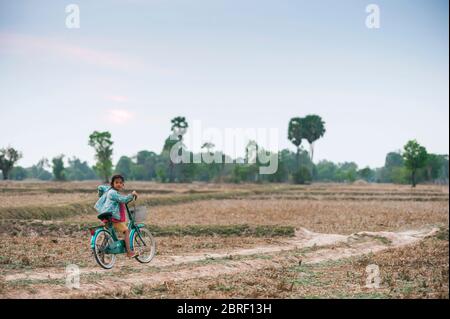 Junge kambodschanische Mädchen auf einem Fahrrad hält auf einer kleinen Strecke. Provinz Siem Reap, Kambodscha, Südostasien Stockfoto