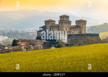 Wahrzeichen italiens, das Fantasy-Schloss Torrechiara bei Parma - Italien mit gelb-warmem Gras und Himmel Vintage-Look mit Kopierraum Stockfoto