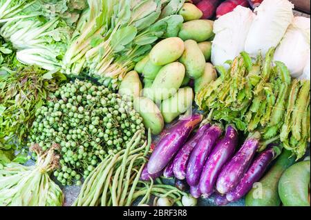 Auberginen, Mangos, Bohnen und anderes Gemüse zum Verkauf bei Psar Nat Market, Battambang, Kambodscha, Südostasien Stockfoto