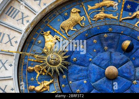 Alte Uhr (Torre dell'Orologio) auf dem Markusplatz in Venedig, Italien. Detail mit gestecktem Gesicht und Tierkreiszeichen. Stockfoto